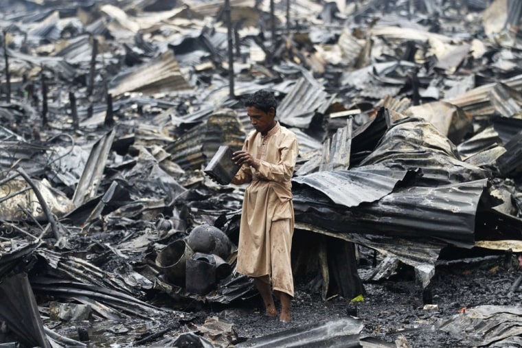 A man salvages his belongings after a fire in a slum at Shyamoli in Dhaka, the Bangladeshi capital, on May 16, 2012.