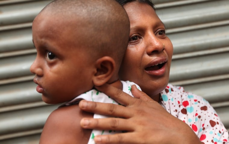A woman cries holding her child after she lost her shanty house in the fire.