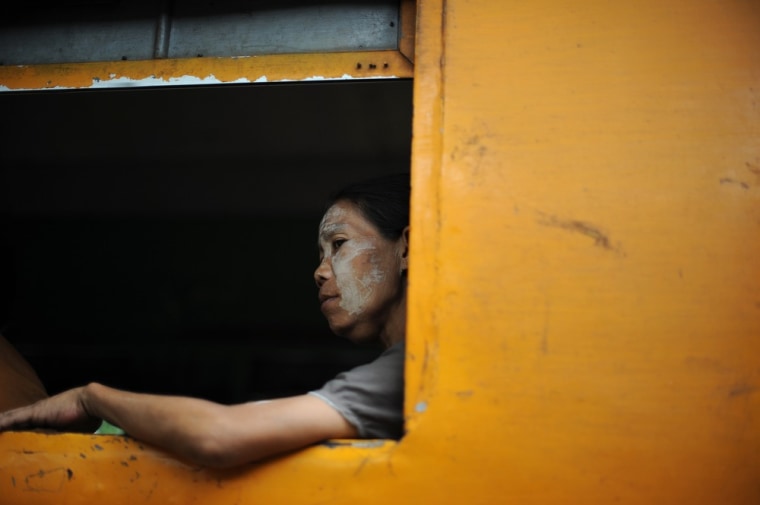A woman looks out from the window as she travels in a train in Yangon, Myanmar, on May 17, 2012.