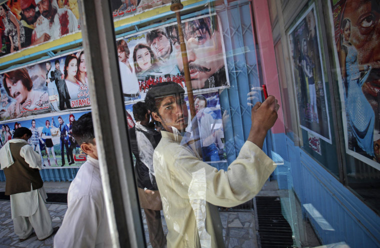 A cinema goer uses his mobile phone to take a photograph of a film poster at Cinema Pamir in Kabul on May 4. Once a treasured luxury for the elite, Afghan cinemas are dilapidated and reflect an industry on the brink of collapse from conflict and financial neglect. Kabul's cinemas show Pakistani films in Pashto, American action films and Bollywood to rowdy, largely unemployed crowds in pursuit of any distraction from their drab surroundings.