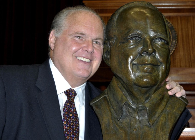Conservative commentator Rush Limbaugh poses next to his gold bust. Limbaugh was inducted into the Hall of Famous Missourians on Monday, May 14, 2012.