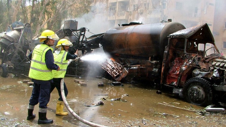 A handout picture released by the Syrian Arab News Agency (SANA) shows Syrian firefighters dousing a burning truck at the site of a blast in the eastern city of Deir Zor Saturday.