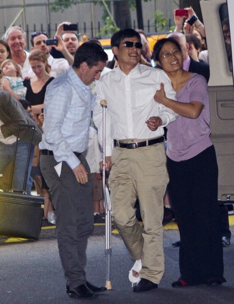 Blind Chinese dissident Chen Guangcheng, center, is helped by his wife, Yuan Weijing, right, after arriving in New York on Saturday.