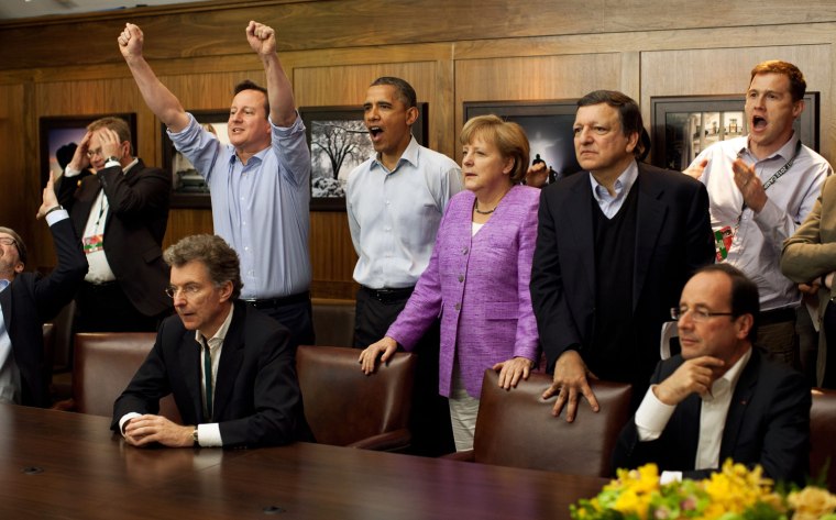 Prime Minister David Cameron of Britain (arms raised), President Barack Obama, Chancellor Angela Merkel of Germany, Jose Manuel Barroso, President of the European Commission, and others watch the overtime shootout of the Chelsea vs. Bayern Munich Champions League final in the Laurel Cabin conference room during the G8 Summit at Camp David, Maryland, May 19.