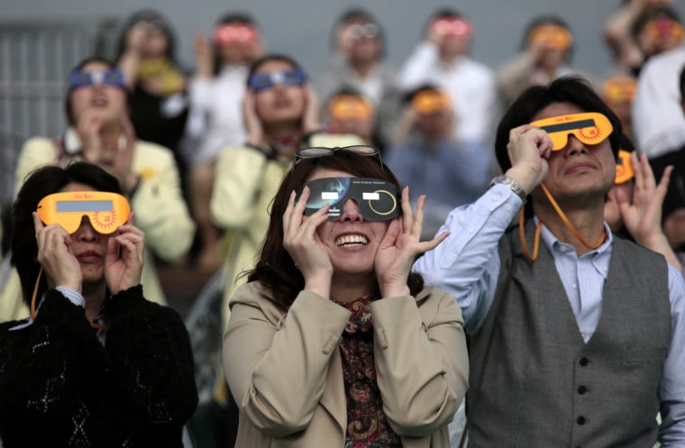 People peer through special glasses to see the annular eclipse of the sun in Tokyo, Japan, May 21. The eclipse was visible from China to Texas.