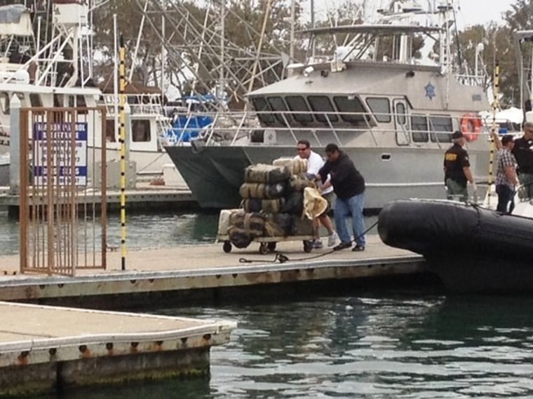Bales of marijuana found floating off the California coast are offloaded onto a dock.