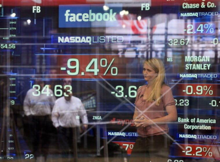 A television reporter stands inside the Nasdaq MarketSite in New York as Facebook's shares fall.