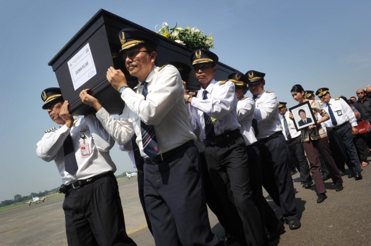 Fellow Indonesian pilots carry the casket of Captain Darwin Pelawi during a turnover ceremony for the bodies of 45 passengers killed on the Russian Sukhoi Superjet 100 at the Halim Perdanakusuma airport in Jakarta on May 23, 2012.