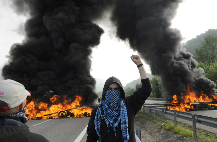 A miner stands in front of burning barricades on the A-66 motorway, on the first day of a strikes to protest against the government's spending cuts in the mining sector, in Pola de Lena, near Oviedo, northern Spain, on May 23.