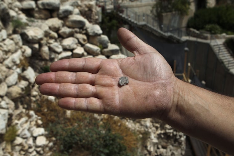 A clay seal recently unearthed by Israeli archaeologists is displayed by Eli Shukron, who directed the excavation on behalf of the Israel Antiquities Authority, just outside Jerusalem's Old City on May 23, 2012.
