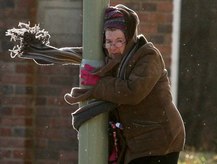 A lady holds on to a lamp post during strong winds at South Shields, England, Jan. 3, 2012.