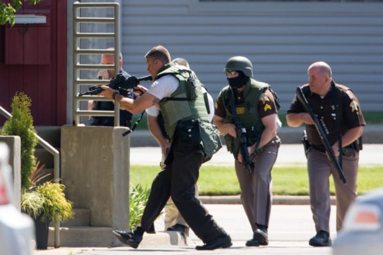 Law enforcement officials advance on the building in Valparaiso, Ind., where a gunman was holding an unknown number of hostages Friday.