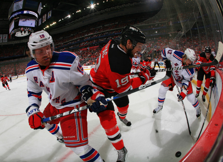 Brad Richards #19 and Carl Hagelin #62 of the New York Rangers fights for the puck against Travis Zajac #19 and Mark Fayne #29 of the New Jersey Devils.