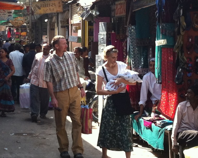 Robyn and Jason Wright with their son Jake, walking through Ananad, India.