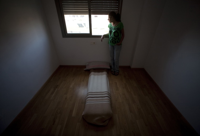 Unemployed Esperanza Pinto, 32, is seen in a bedroom in the apartment where she lives with her daughter in the Andalusian capital of Seville, southern Spain May 23.