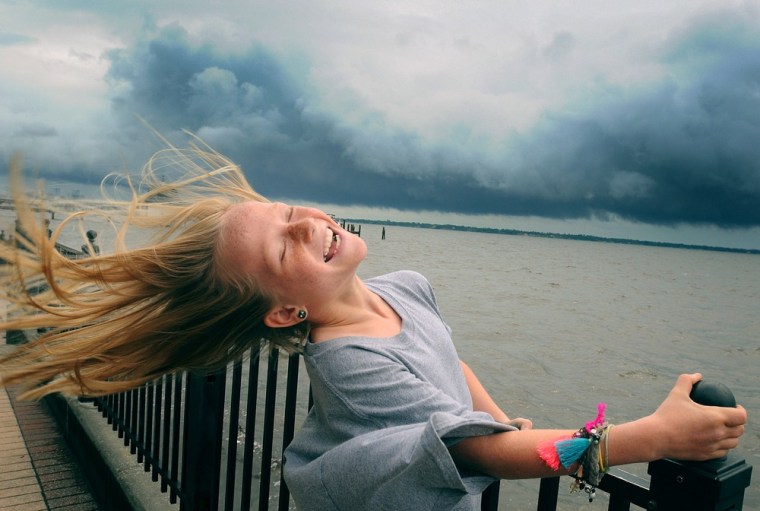 Winnie Pajcic, 9, holds on to a railing as she leans back in the wind during a visit to Stockton Park in Ortega, Fla., in the aftermath of Tropical Storm Beryl on May 28.
