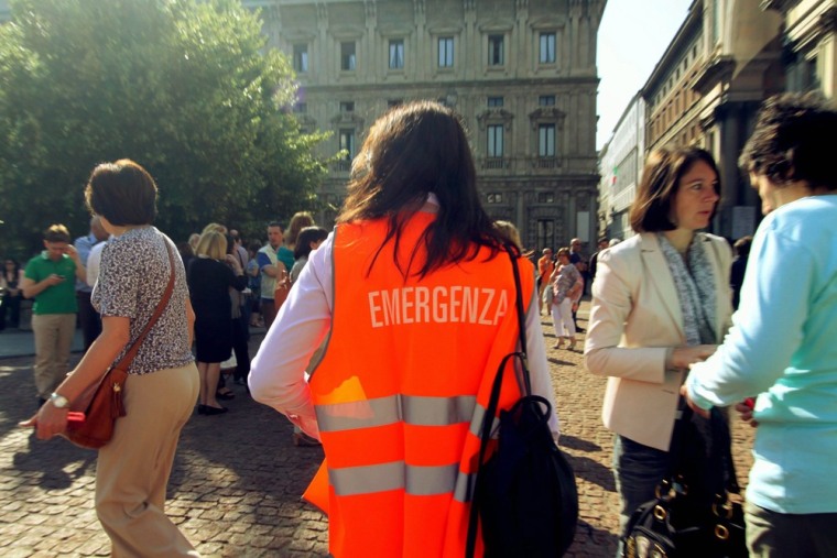 A volunteer helps people evacuate the Tesoreria Comunale and Marino Palace offices in downtown Milan after Tuesday's earthquake.