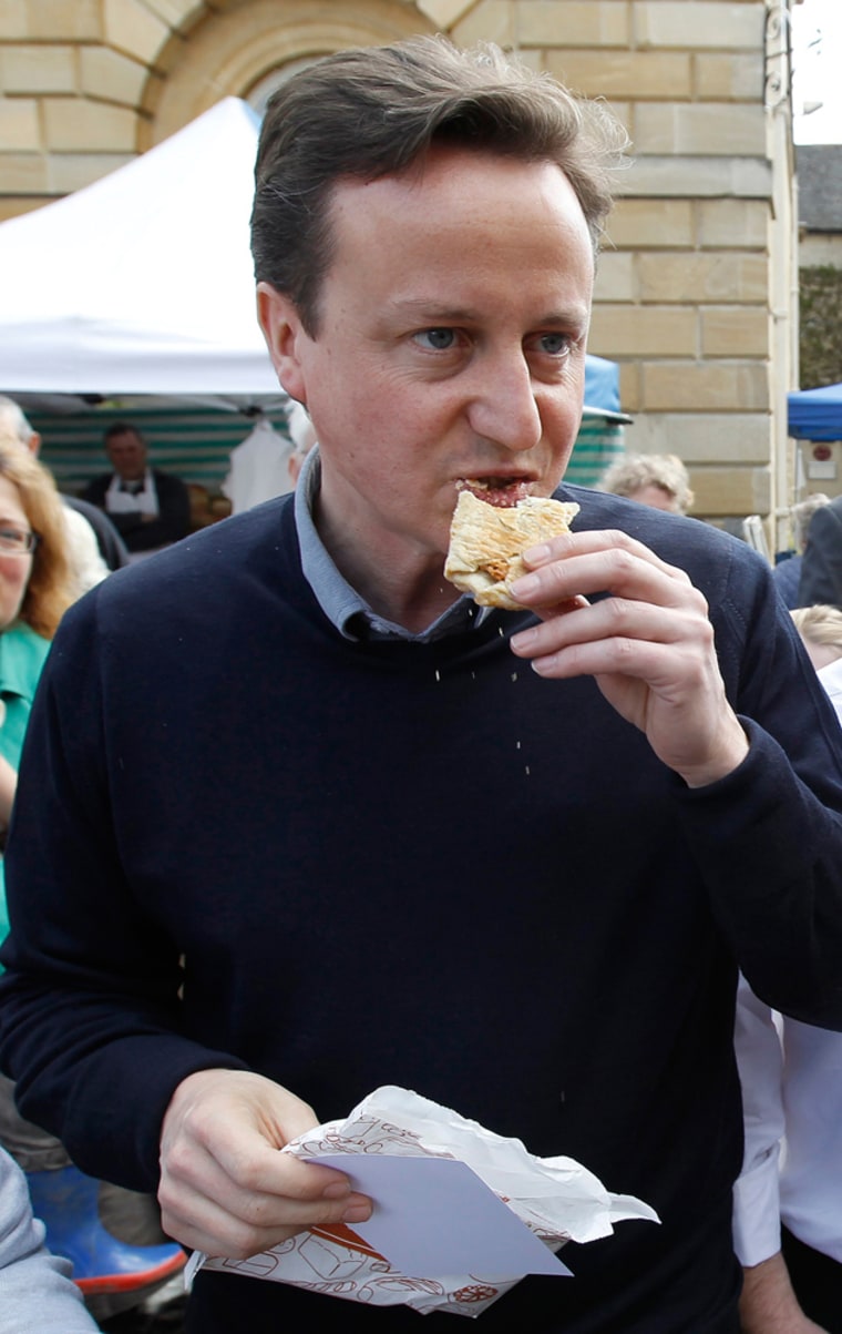 David Cameron eats a pastry during an election campaign stop on May 1, 2010 in Woodstock, southern England.