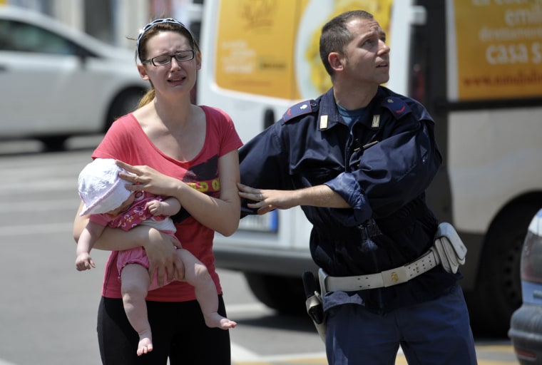 An Italian policeman helps a woman and her baby during an aftershock in Mirandola, northern Italy, Tuesday, May 29, 2012. A magnitude 5.8 earthquake struck northern Italy on Tuesday, killing at least 10 people as factories, warehouses and a church collapsed in the same region still struggling to recover from another deadly tremor nine days ago.