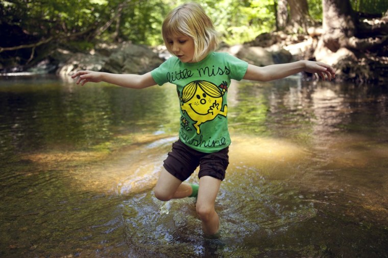 Lori Anne Madison, 6, of Lake Ridge, Va., walks through river water while playing with friends in a park in McLean, Va., on May 11.