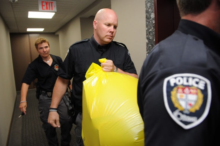 A police officer removes a package from the Conservative party headquarters in Ottawa, Canada, on Tuesday.