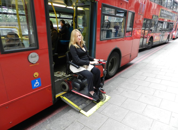 Laura Hamilton exits a double-decker bus in London.