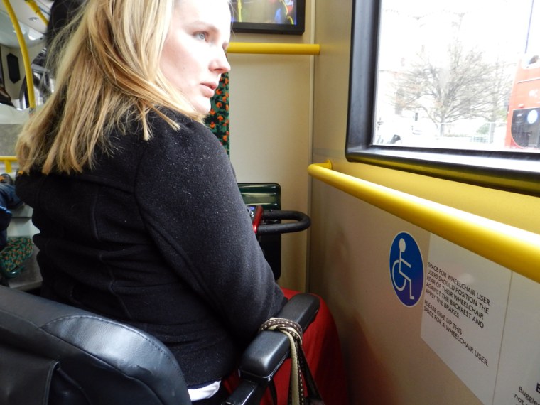 Laura Hamilton in the handicapped section of a double-decker bus in London.