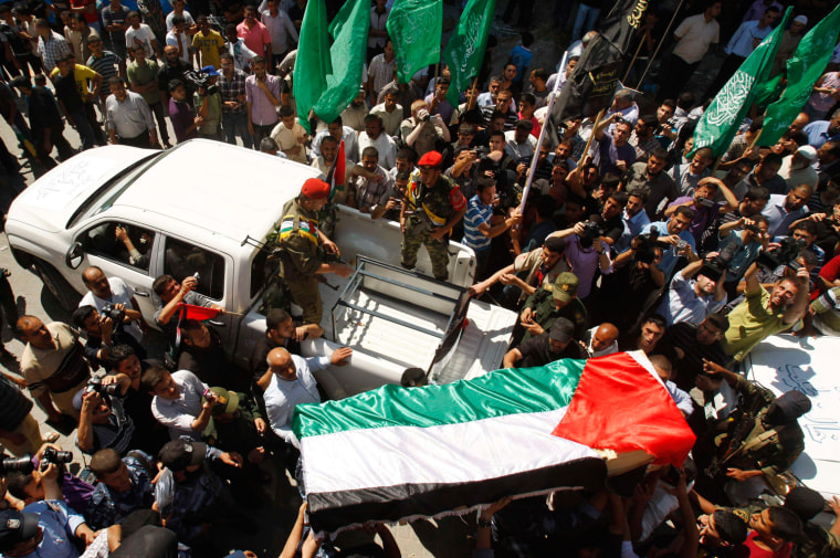Palestinians carry a flag-covered coffin containing the remains of a Palestinian militant outside a hospital morgue in Gaza City on May 31. The remains of 91 Palestinian militants whose attacks killed hundreds of Israelis were returned to the West Bank and Gaza on Thursday in a gesture Israel said it hoped could help revive peace efforts.