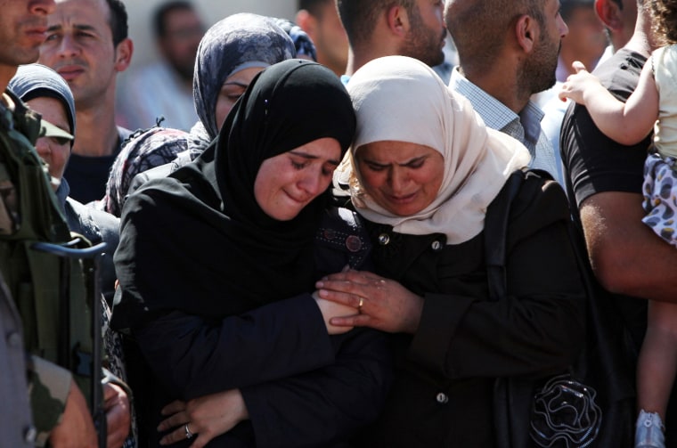Palestinian women mourn during the funeral of 91 Palestinians whose remains were returned by Israel at the Palestinian headquarters in the West Bank city of Ramallah on May 31. Israel handed over the remains of scores of Palestinian militants killed in attacks against Israel, a Palestinian official said.