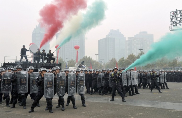 Police officers and forces from the Special Weapons and Tactics (SWAT) practice to disperse crowd in a joint drill to reinforce security for the coming 18th National Congress of the Communist Party of China, in Zhengzhou, Henan province, on Tuesday.