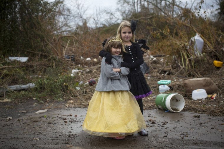 Lisa and Julia Kravchenko pose in their Halloween costumes as they stand in an area ruined by Hurricane Sandy in Staten Island, New York, on October 31, 2012.
