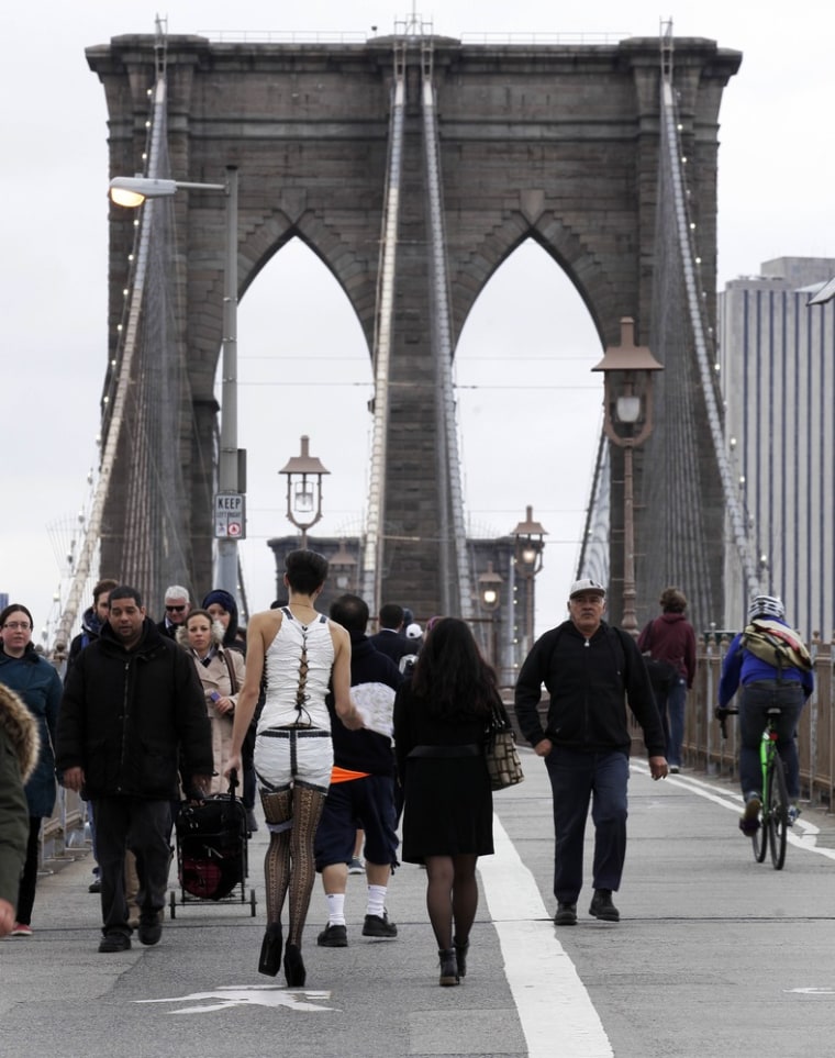Commuters, including one man dressed for Halloween, cross New York's Brooklyn Bridge on Oct. 31, 2012.