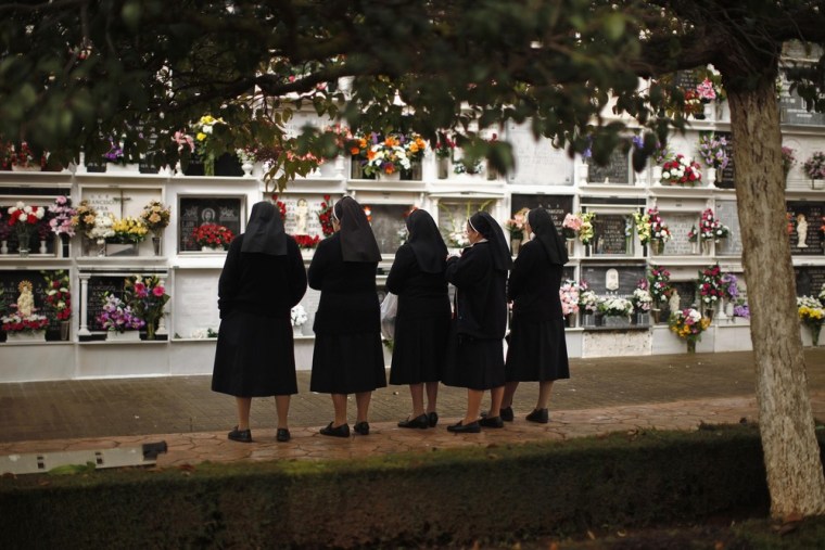 Catholic nuns from the congregation Saint Jose of the Mountain pray as they visit a tombstone on All Saints Day in the cemetery of San Lorenzo in Ronda, near the southern Spanish city of Malaga.