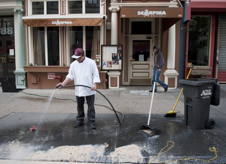 Manuel Carpina cleans food debris left after the garbage was collected at his restaurant, Scarpina Bar & Grill in New York, N.Y. on Nov. 1, 2012. Flooding and lack of electricity caused by Hurricane Sandy left parts of New York City in a mess.