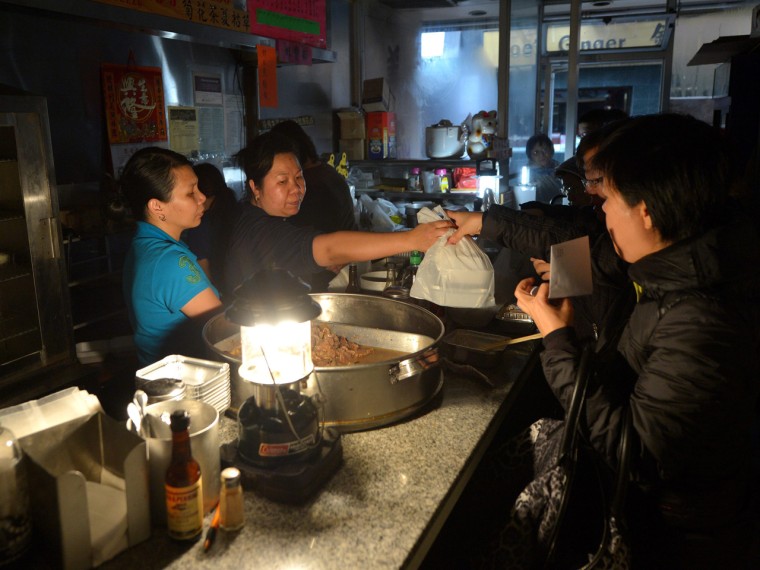 Food is served in the dark at the Mee Sun Cafe in Chinatown on Tuesday as power to most of lower Manhattan was lost after Superstorm Sandy hit in New York. Mee Sun was one of a number of cafes, restaurants and bars that managed to serve customers this week in harrowing conditions.