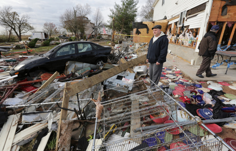 Staten Island resident John Dellorusso looks over his backyard, which now contains debris from a nearby restaurant. His Yetman Avenue home, at right, was severely damaged. The homeowner next door and his 13-year-old daughter were killed when their house was flattened.