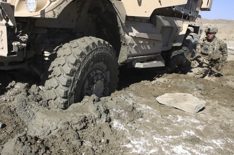A soldier of B Troop, 1st squadron of the 4th US Cavalry Regiment works with a shovel next to a mired truck near COP (Combat Outpost) Sar Howza in Paktika province on October 29, 2012.