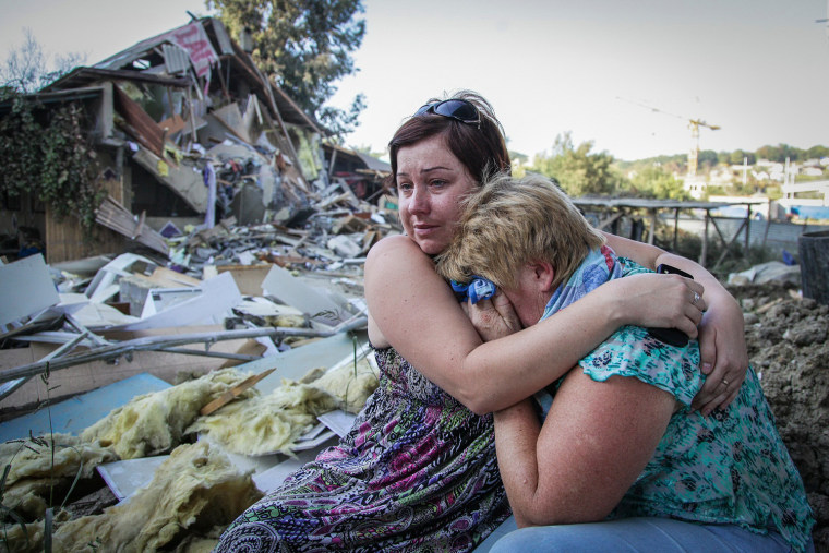 Tatyana Samokhval, left, daughter of local resident Sergei Khlystov, embraces her crying mother Valentina Khlystova in front of their partially demolished house in the Black Sea city of Sochi, Russia. The workers arrived at Sergei Khlystov's gate on a Friday evening to bulldoze his home and clear a path for sewage pipes to the Olympic village being built in the Russian city of Sochi. Khlystov and his 33-year-old son-in-law, Maxim Samokhval, at first tried to block the bulldozers but then stood aside and watched as the two-storey house was destroyed. The earthmovers ended Khlystov's battle to stay in his house, one of the last razed in the Mirny neighbourhood to make way for the Winter Olympics in 2014. Picture taken Sept. 19.