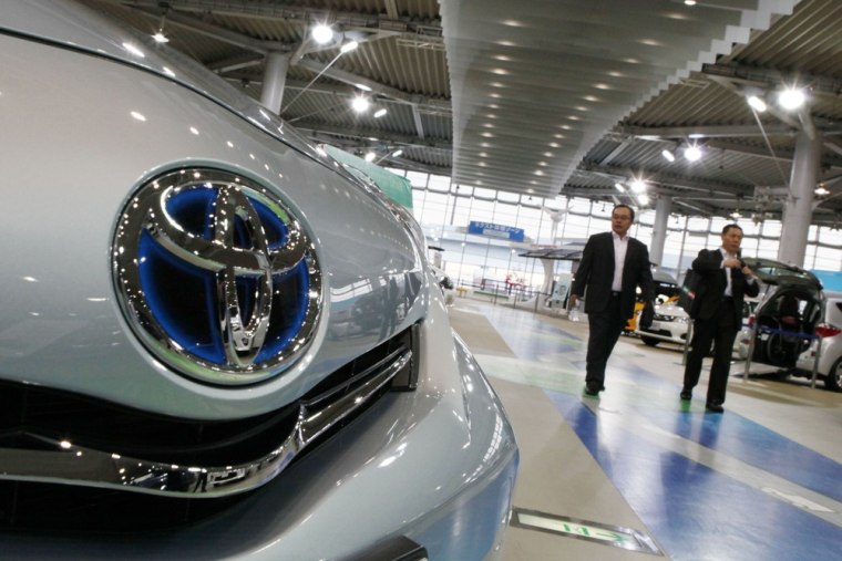Visitors walk through Toyota vehicles at a showroom in Tokyo Monday, Nov. 5, 2012. Toyota's quarterly profit tripled and the company raised its full-...