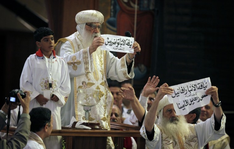 Acting Pope Pachomios, center, displays the name of 60-year-old Bishop Tawadros, soon to be Pope Tawadros II, while another clergyman displays the names of the remaining two candidates, Bishop Raphael and Father Raphael Ava Mina, during the papal election ceremony on Nov. 4, 2012.