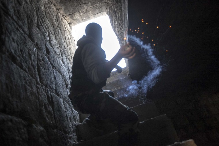 A rebel fighter prepares to throw a homemade grenade toward Syrian troops hiding in a nearby building in the Jedida district of Aleppo on Nov. 04, 2012.