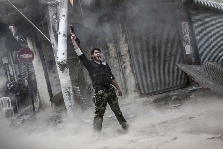 A rebel fighter celebrates after he fired a shoulder-fired missile toward a building where Syrian troops were hiding in the Jedida district of Aleppo on Nov. 04, 2012.