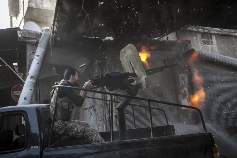 A rebel fighter fires a gun toward a building where Syrian troops loyal to President Assad are hiding while they attempt to gain terrain against the rebels during heavy clashes in the Jedida district of Aleppo, Syria on Nov. 04, 2012.