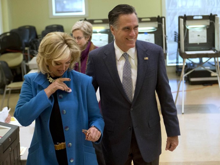 Republican presidential candidate Mitt Romney smiles as his wife Ann dons an