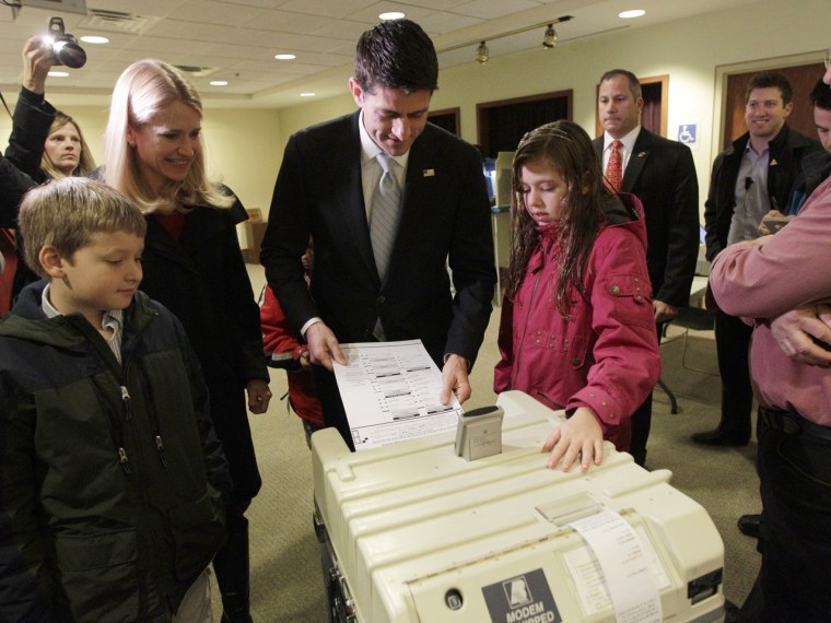 Republican vice presidential candidate Paul Ryan casts his ballot in Janesville, Wis., on Tuesday as his wife Janna, son Charlie and daughter Liza look on.