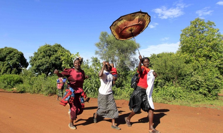 Relatives of U.S. President Barack Obama sing and dance as they run along a dirt road during celebrations for his re-election at his ancestral home village of Nyangoma Kogelo, 367 miles west of Kenya's capital Nairobi, on November 7, 2012.