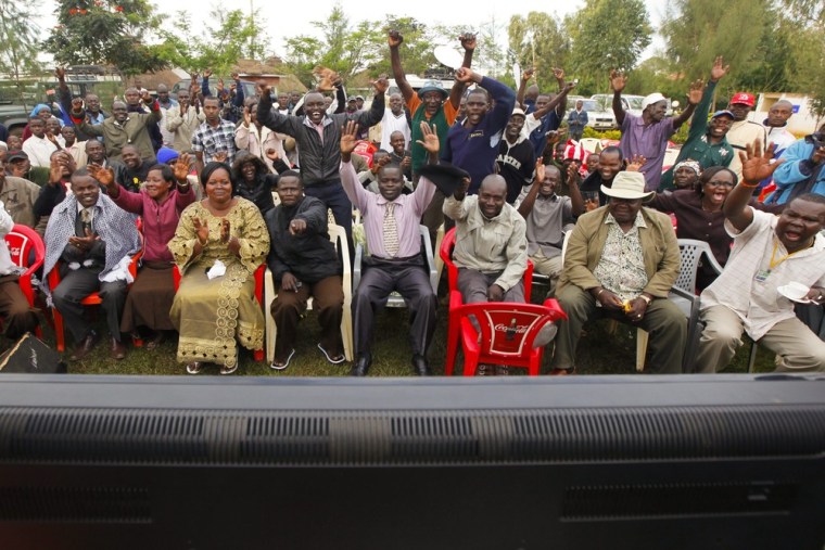 Kenyan supporters of Barack Obama react as they watch the news coverage announcing Obama's victory in Nyang'oma Kogelo village on November 7, 2012.