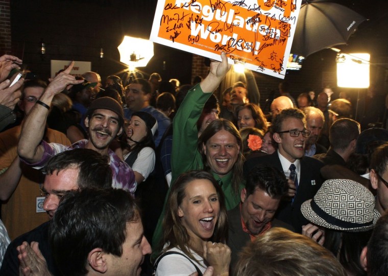 People celebrate in a Denver bar after a local television station announced the passage of Colorado's marijuana amendment on Tuesday, Nov. 6, 2012.