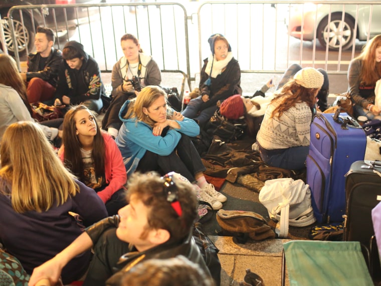 Dedicated mom: Patty Bousetta, center left in blue jacket, sits in the blocked off area for the One Direction near Rockefeller Center the evening befo...