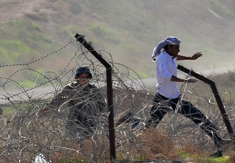 A Syrian man runs away followed by a Turkish soldier in the Turkish border town of Ceylanpinar, near the Syrian town of Ras al-Ain, on November 14, 2012.
